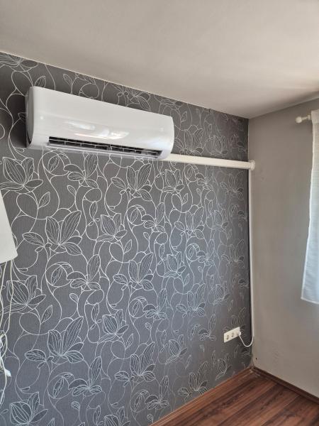 Fehér beltéri egység mintás tapétájú szobában – klímaszerelés, Balázs Klíma
